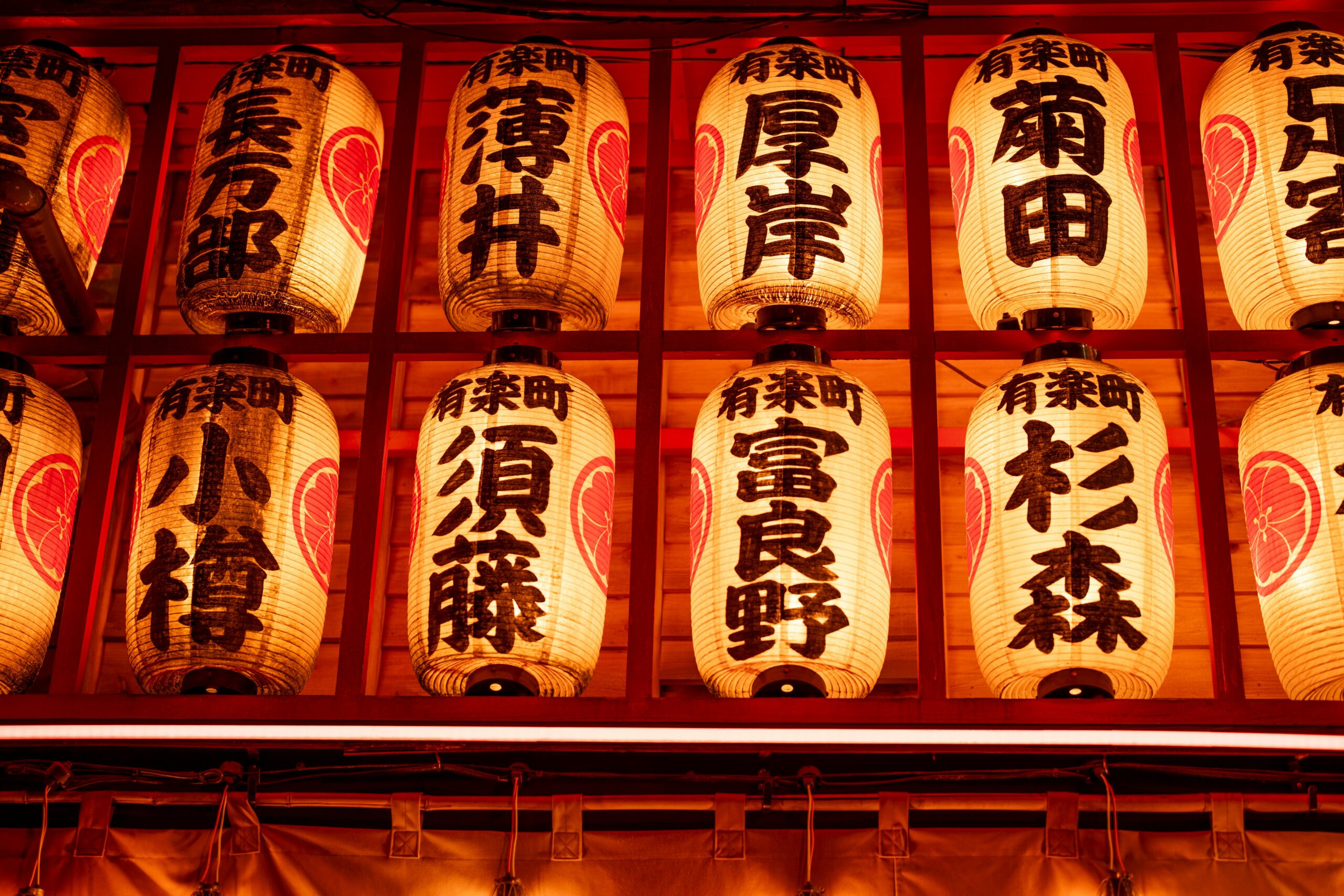 Illuminated traditional Japanese lanterns in a Tokyo shrine at night, showcasing cultural heritage.