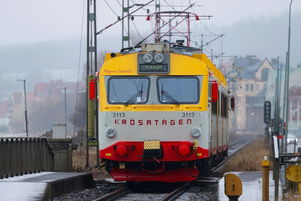 Vibrant train arriving at Jönköping central station on a misty day in Sweden.
