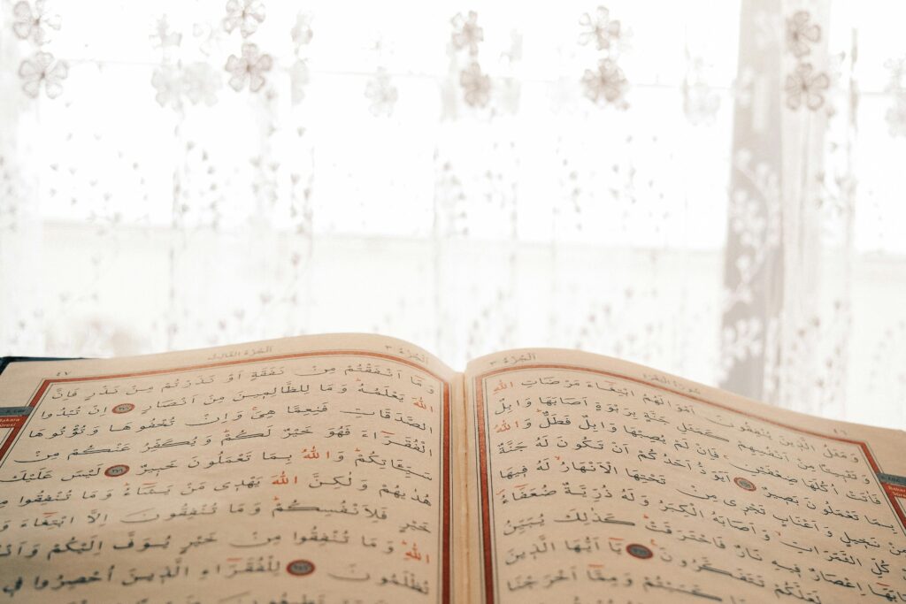Open Arabic text book with elegant floral curtain backdrop. Perfect for cultural and educational themes.