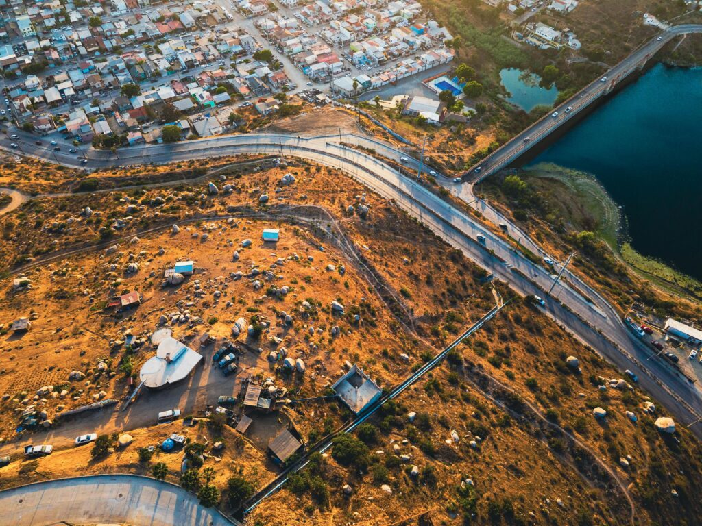 Aerial shot capturing urban and rural contrast with roads and lake.