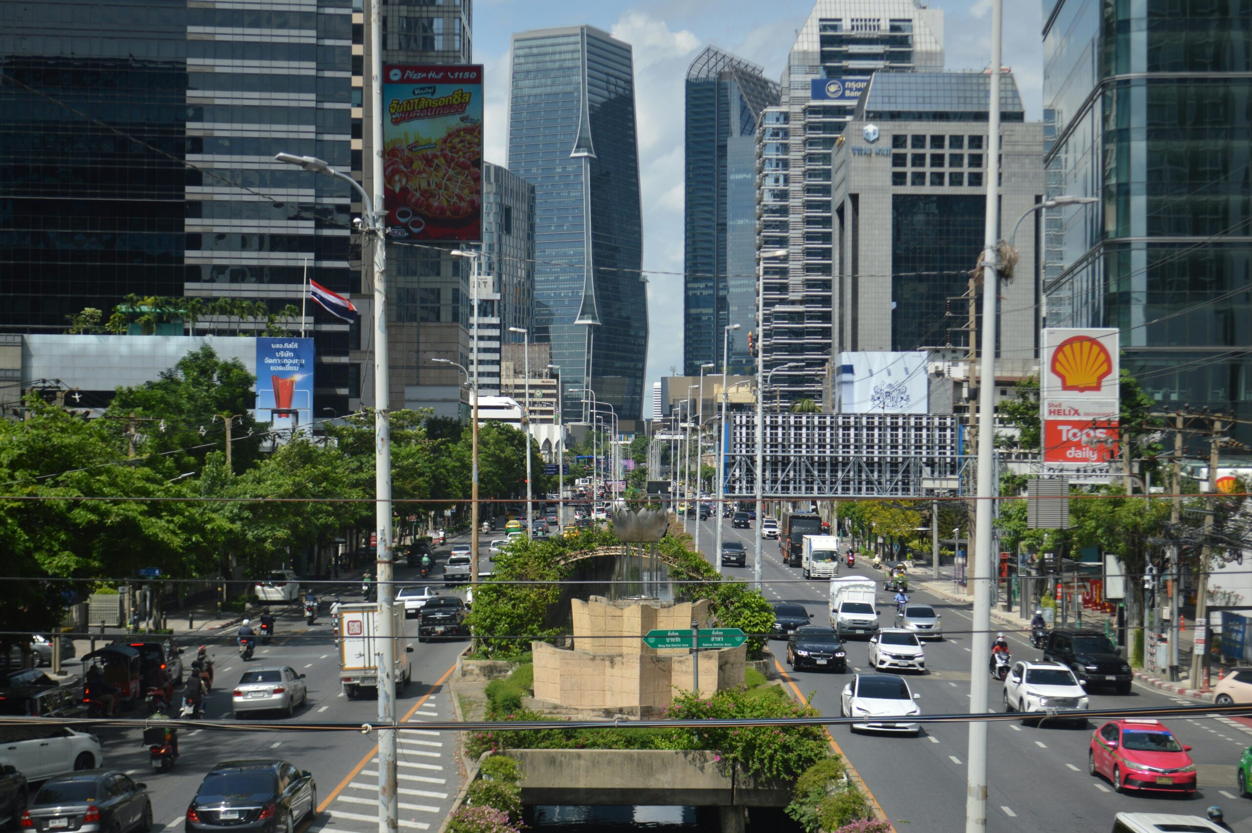 A vibrant view of Bangkok's bustling business district with modern skyscrapers and heavy traffic.