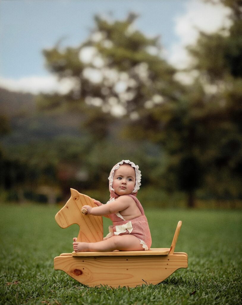 Cute baby riding a wooden rocking horse outdoors in Tingo María, Huánuco, Peru.