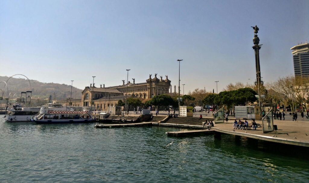 Beautiful view of Barcelona's port area with historic architecture and waterfront activity.