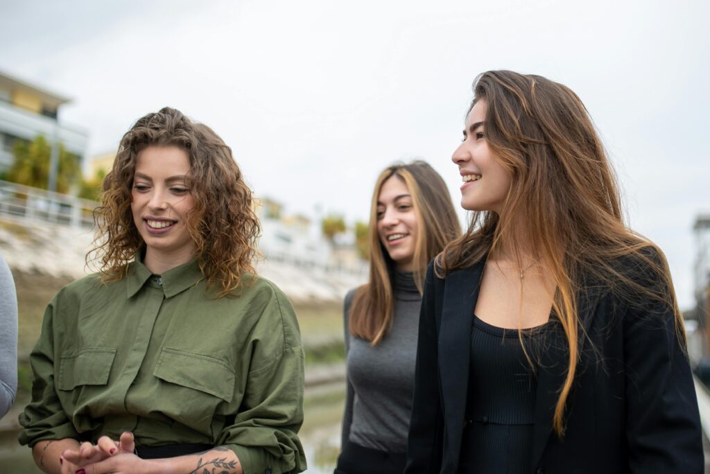 Three women enjoying a day outdoors together, smiling and having fun in Portugal.