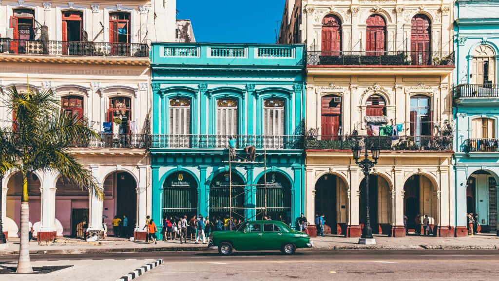 Vibrant colonial buildings and classic car on a sunny street in Havana, Cuba.