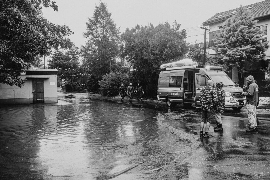 Black and white photo capturing emergency response team during an urban flooding scenario.