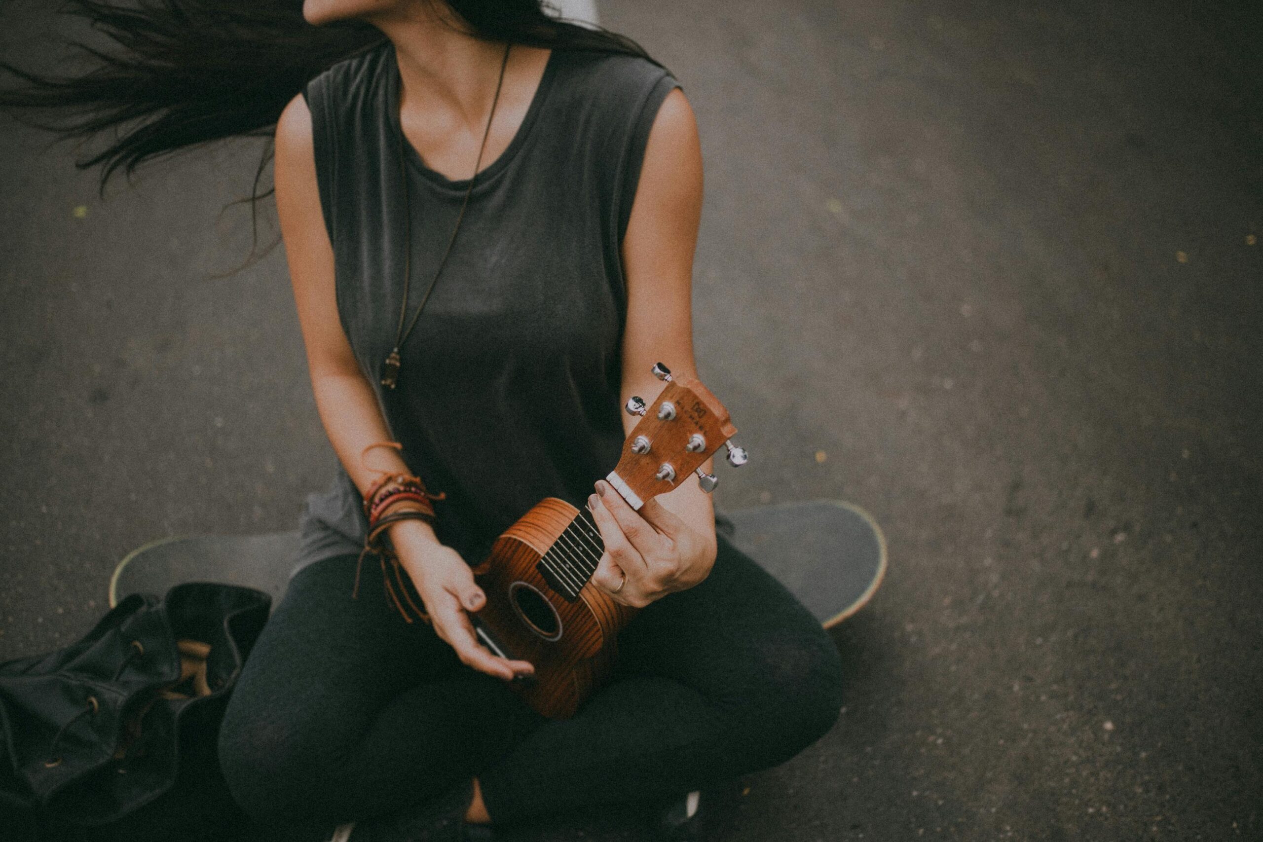 Woman playing a ukulele on a skateboard in Rio de Janeiro, Brazil.