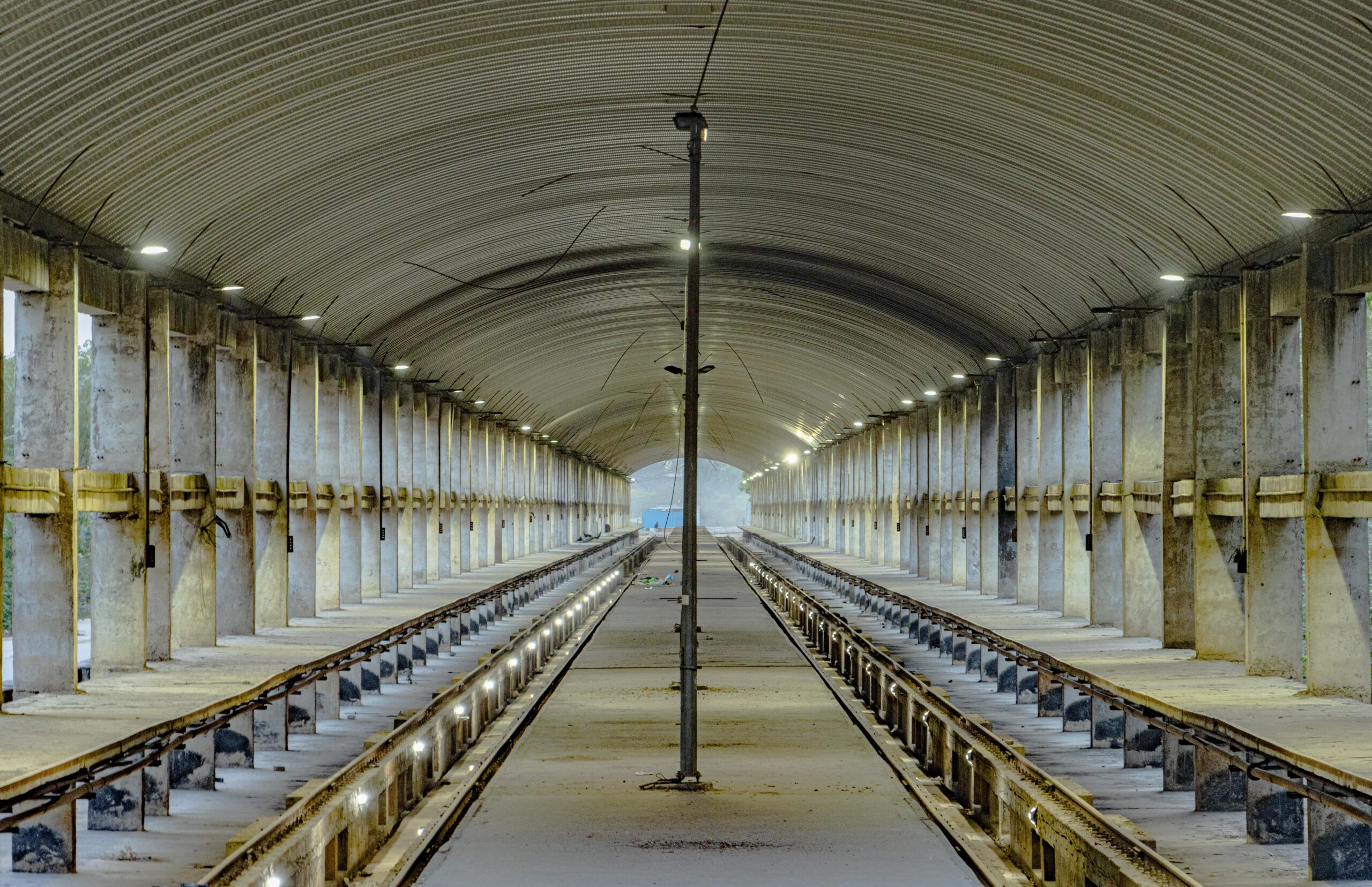Explore an abandoned train station in Delhi, featuring striking concrete architecture under a vaulted ceiling.