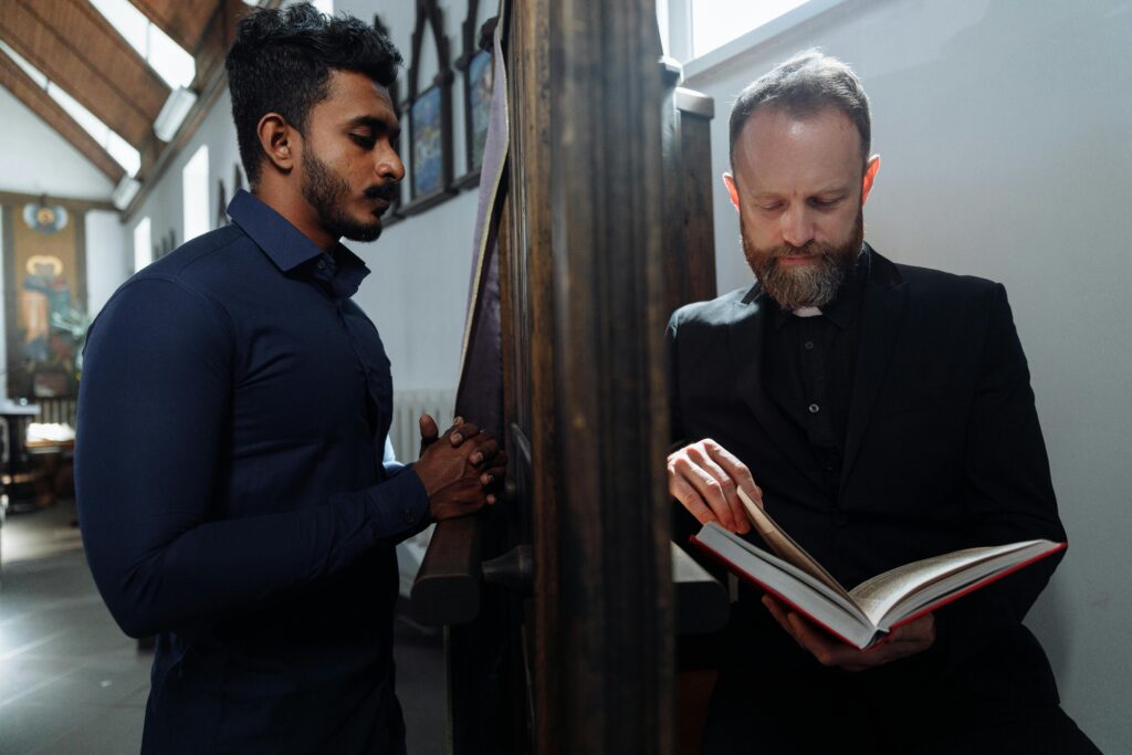 A solemn moment of confession between a devoted man and a priest in a church setting.