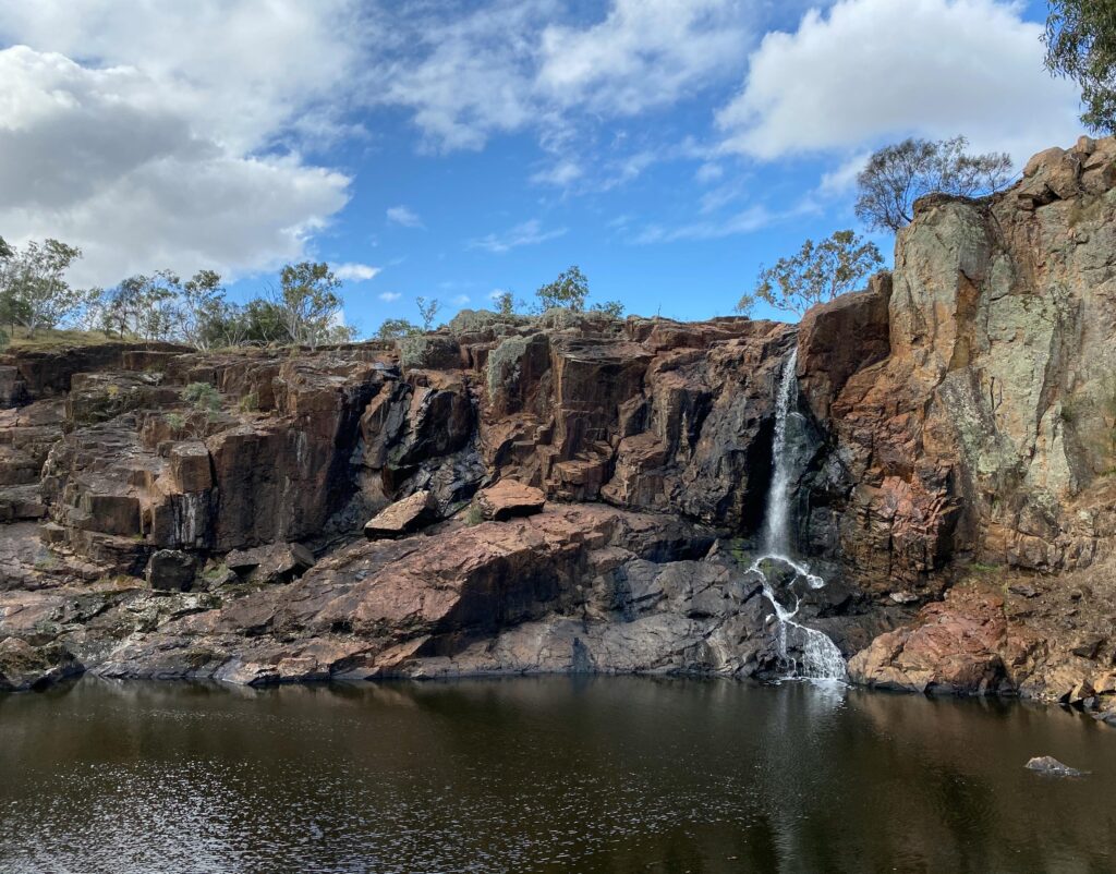 Scenic view of a small waterfall cascading over rocky cliffs in Grampians National Park, Australia.