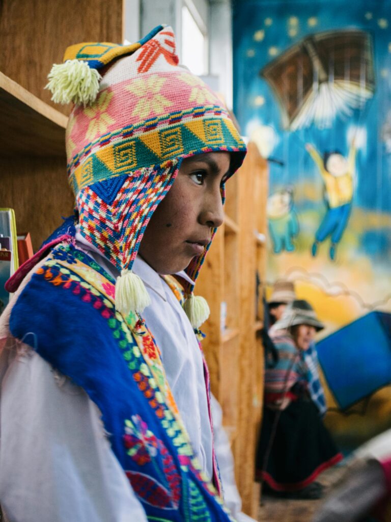 A vibrant portrait of a young boy in traditional Peruvian attire indoors.