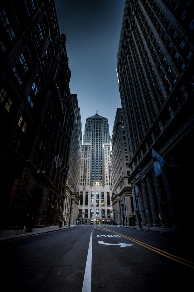 Majestic view of Chicago skyscrapers along an empty street at dusk, showcasing urban architecture.
