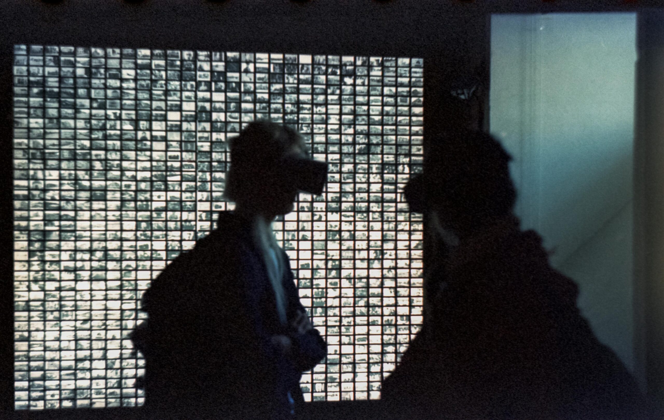 Silhouettes of people wearing VR headsets in front of a grid display, creating a futuristic atmosphere.