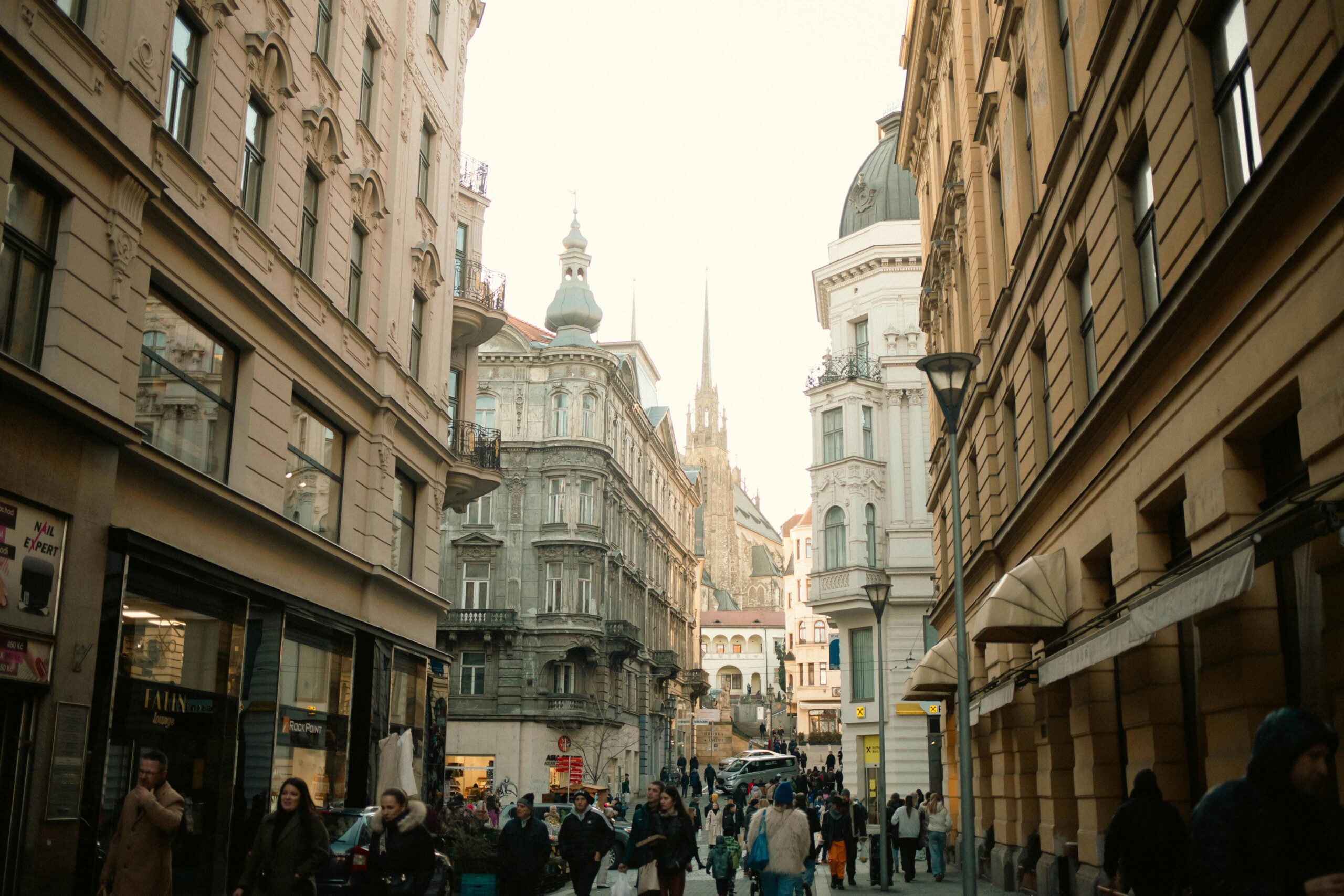 Street scene in Brno, Czech Republic, showcasing busy pedestrians and historic architecture.