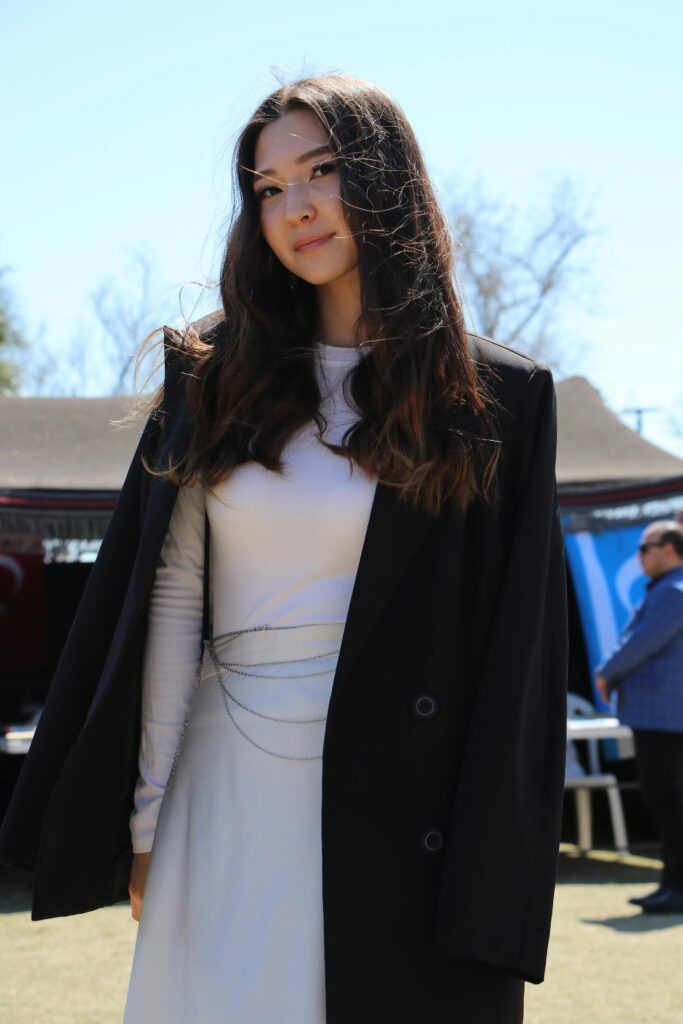 Elegant woman in a chic outfit enjoying a sunny day at an outdoor gathering in Antalya, Türkiye.