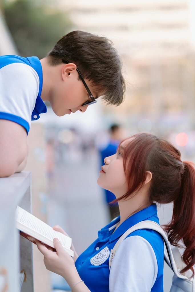 A young couple exchanging glances while studying outdoors, capturing a moment of connection.