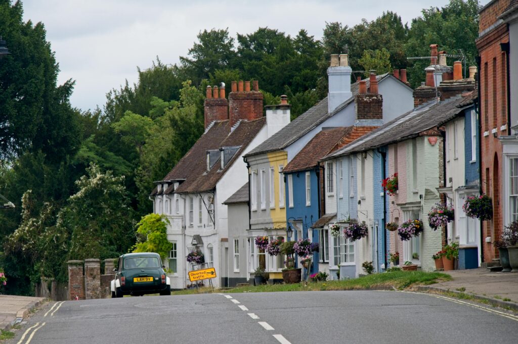 Colorful houses and classic car on a quaint street in New Alresford, England.