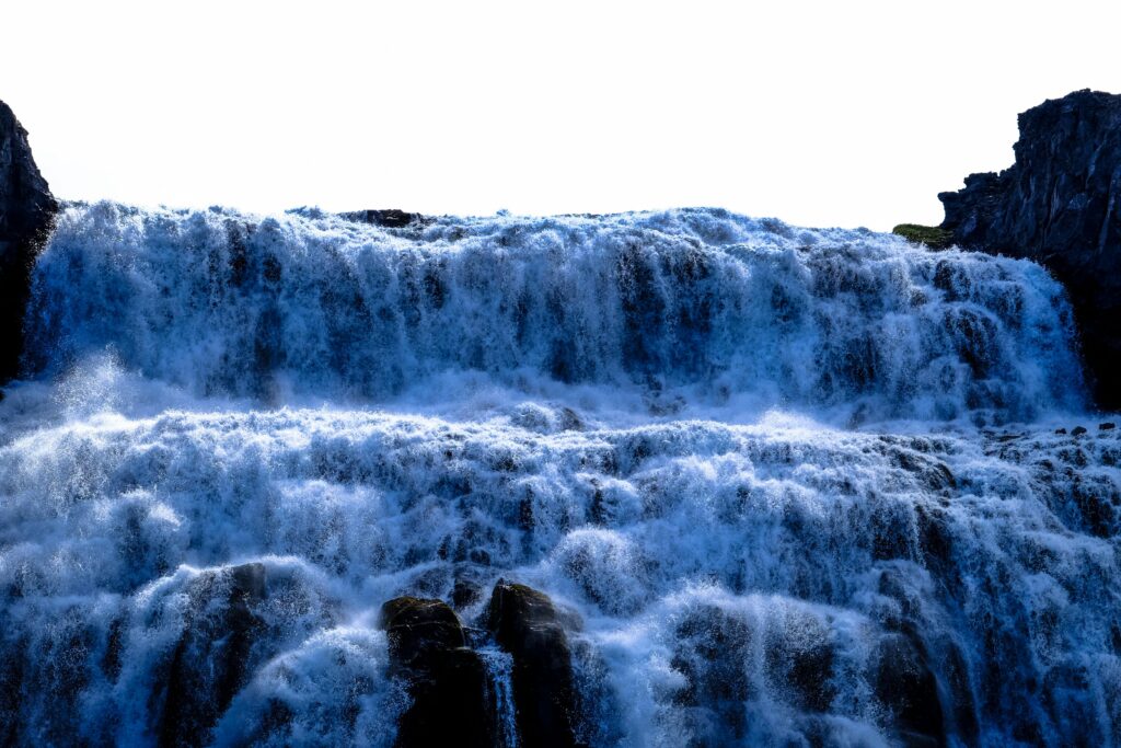 Breathtaking winter waterfall cascading over rugged rocks with icy formations.