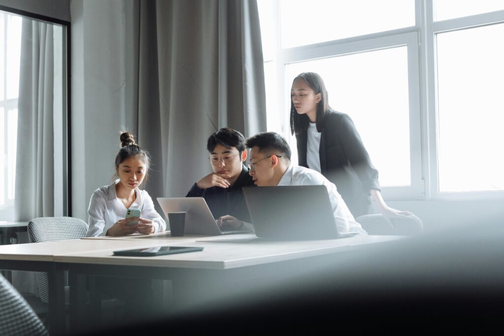 Group of young professionals working together in a bright, modern office space.