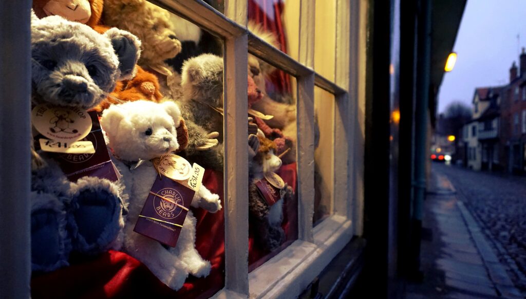 Cozy shop window with teddy bears in Norfolk, England. Perfect for home décor and gift ideas.
