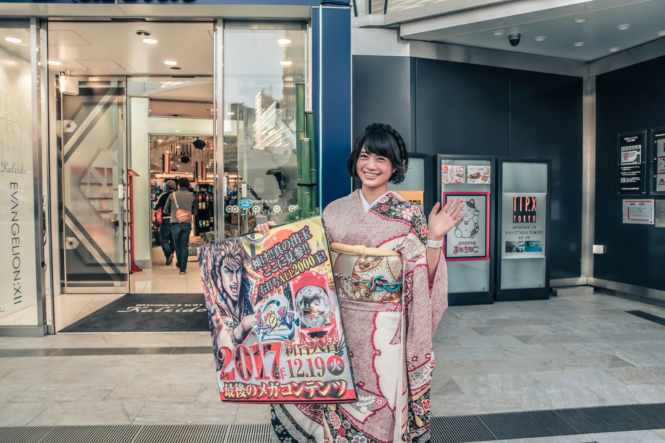 Asian woman in kimono holding promotional sign outside a store.