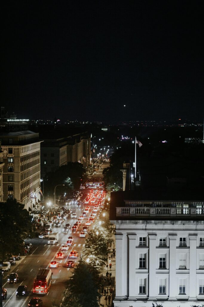 Aerial view of bustling Washington, DC streets at night with vibrant streetlights and traffic.