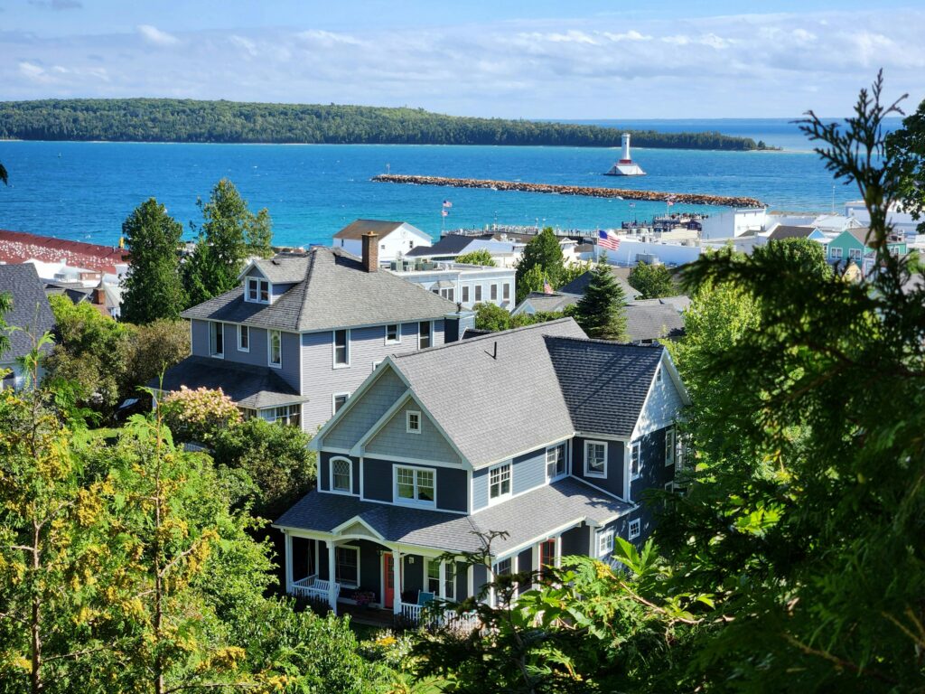 Scenic view of coastal homes by the sea with a lighthouse in the background.