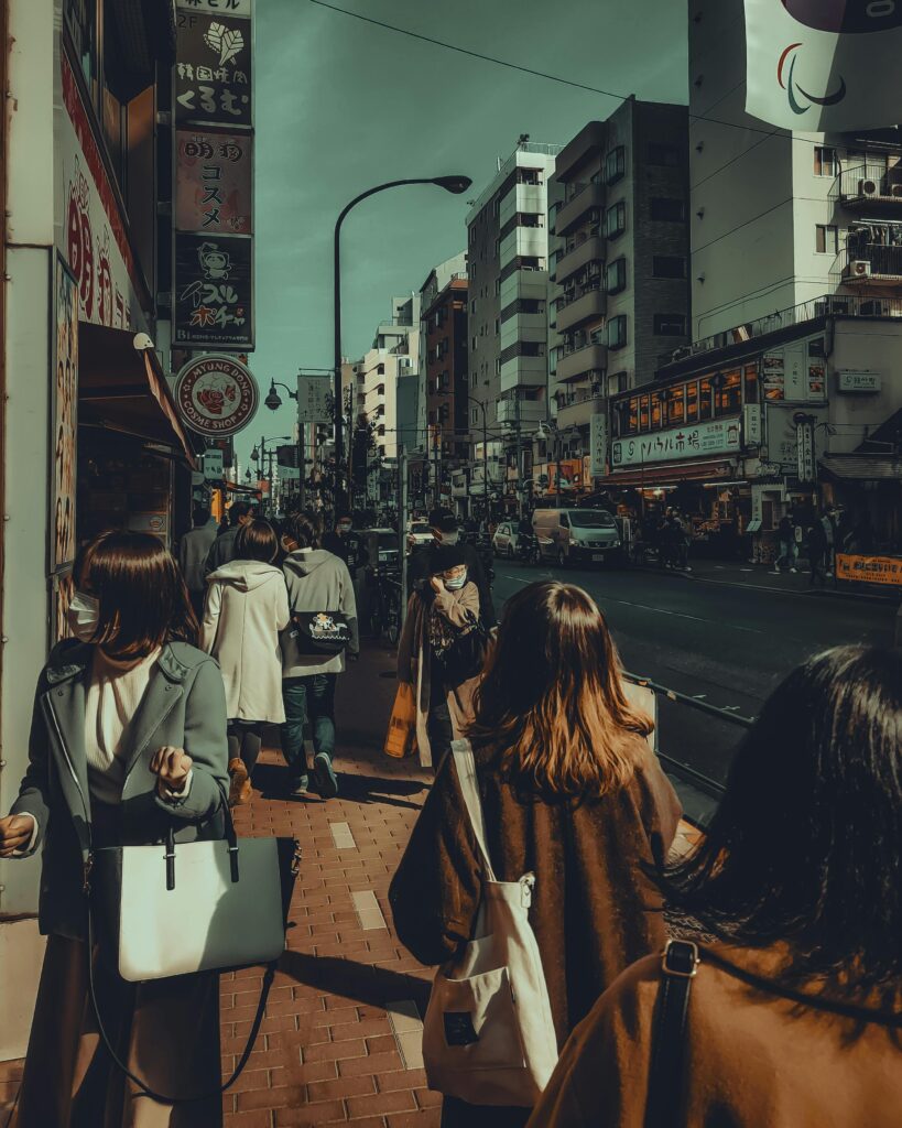 A busy street scene in Tokyo showcasing urban life with people strolling amidst city buildings.