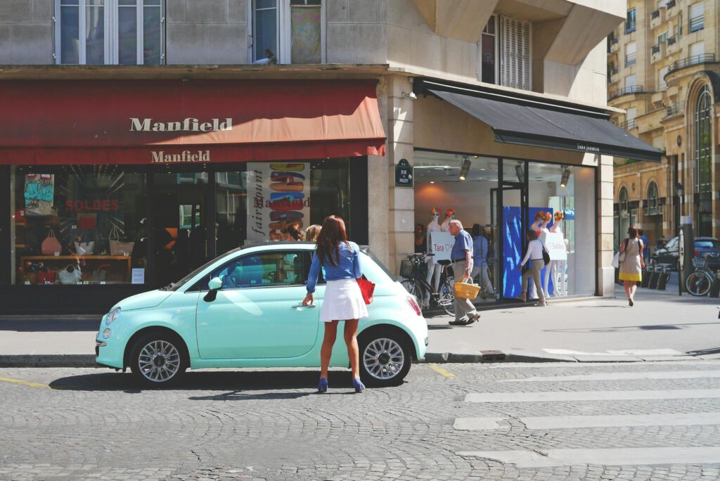 A vibrant day in Paris featuring pedestrians and a stylish woman near a boutique.