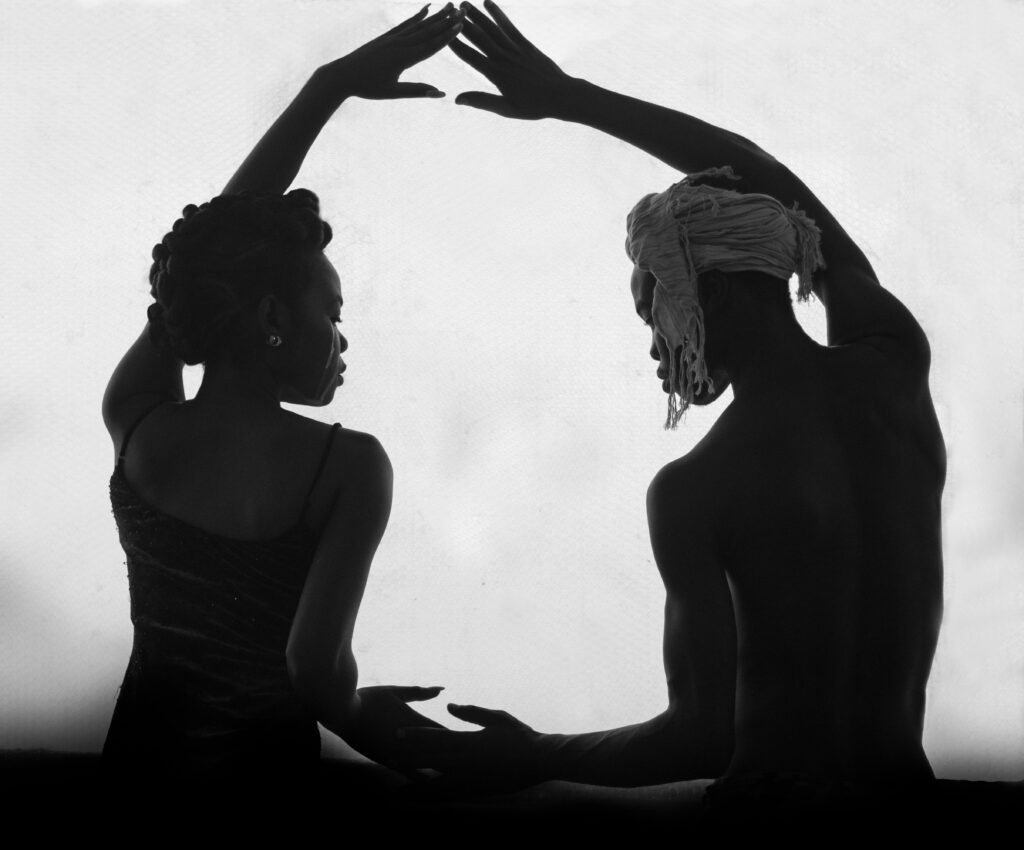 Silhouette of a man and woman creating a graceful dance pose, capturing unity and elegance in monochrome.
