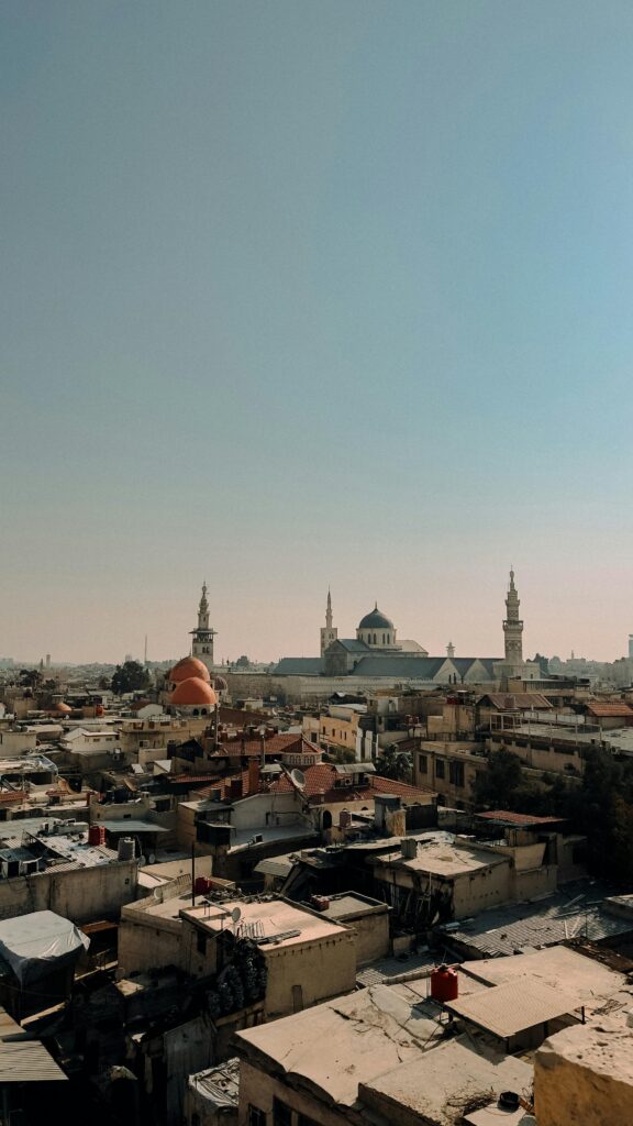 A stunning wide-angle view of an ancient Middle Eastern city with historic mosques under a clear sky.