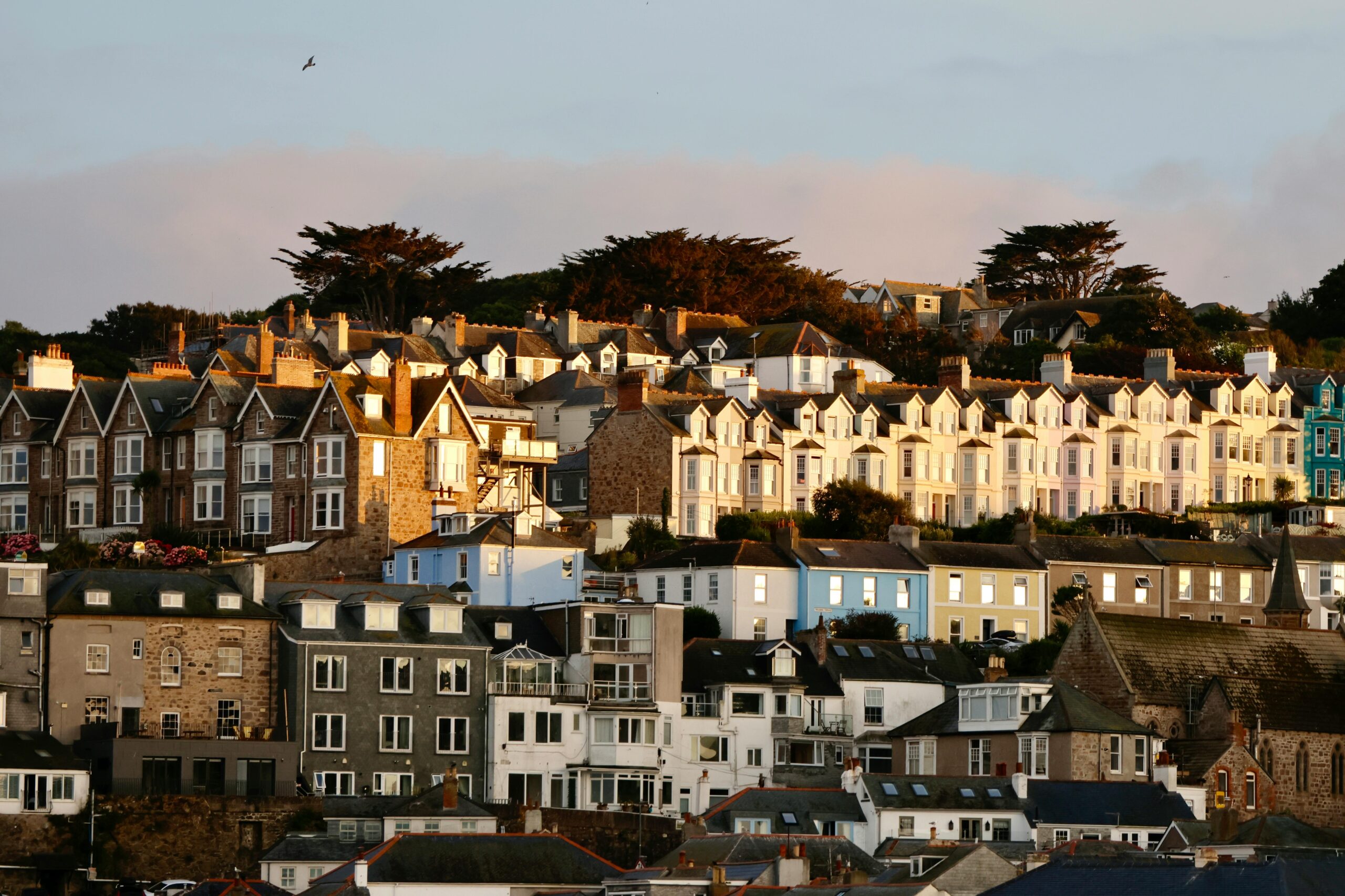 Golden hour highlights the charming rooftops of St Ives, England, creating a picturesque scene.