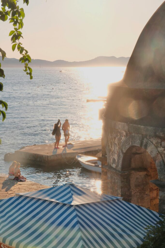 Scenic view of Zadar's waterfront during sunset with people enjoying the serene sea.