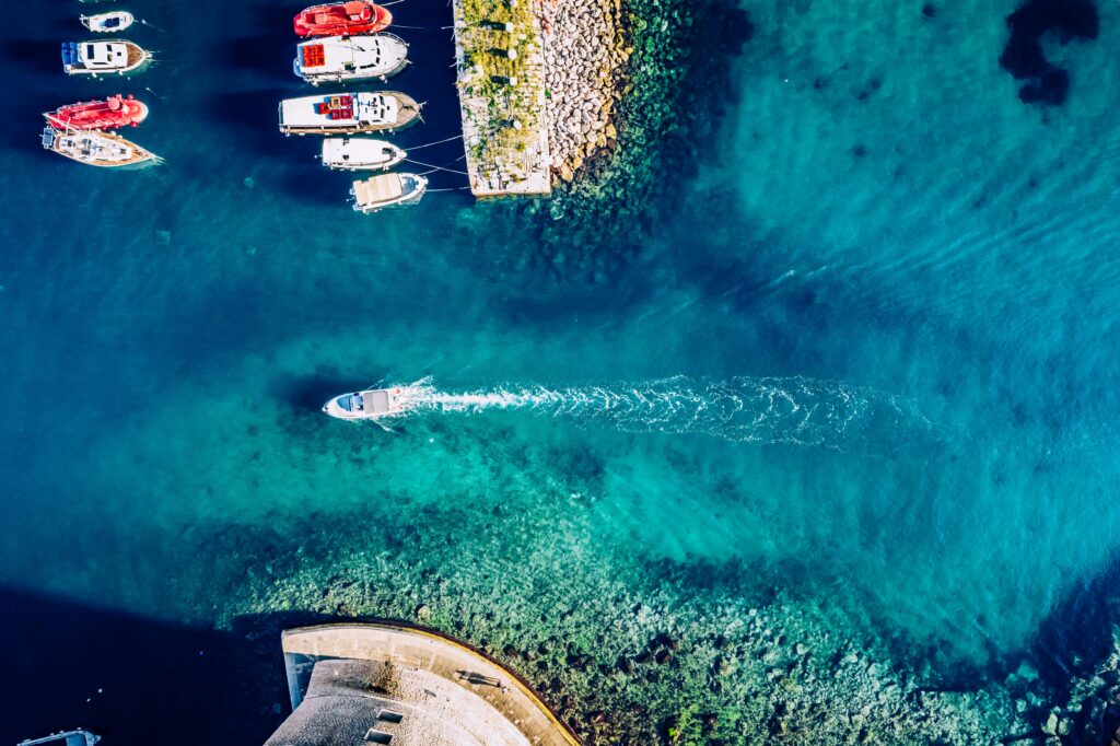 Stunning aerial view of boats and clear turquoise waters along the Adriatic coast in Dubrovnik, Croatia.