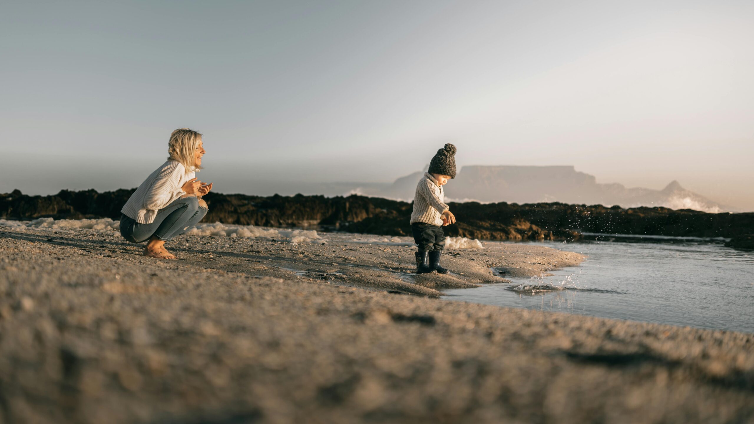 A mother and child enjoying a serene day by the beach, capturing quality family time.