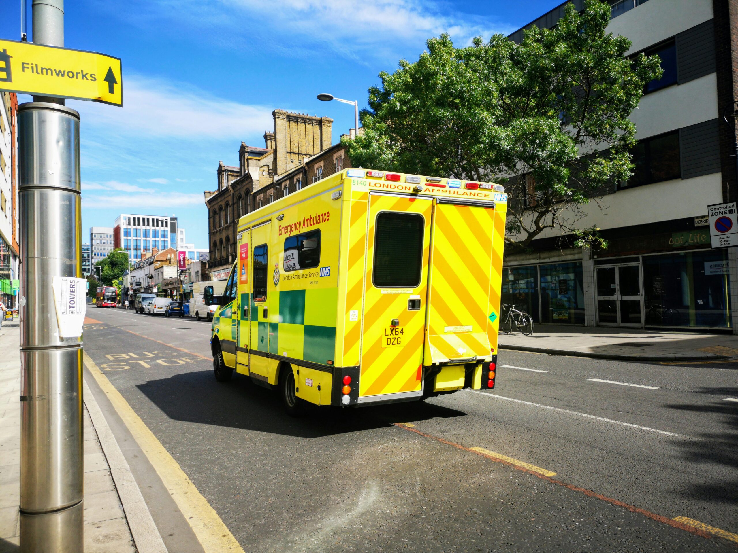 A London emergency ambulance driving through a city street in England, showcasing public health service.