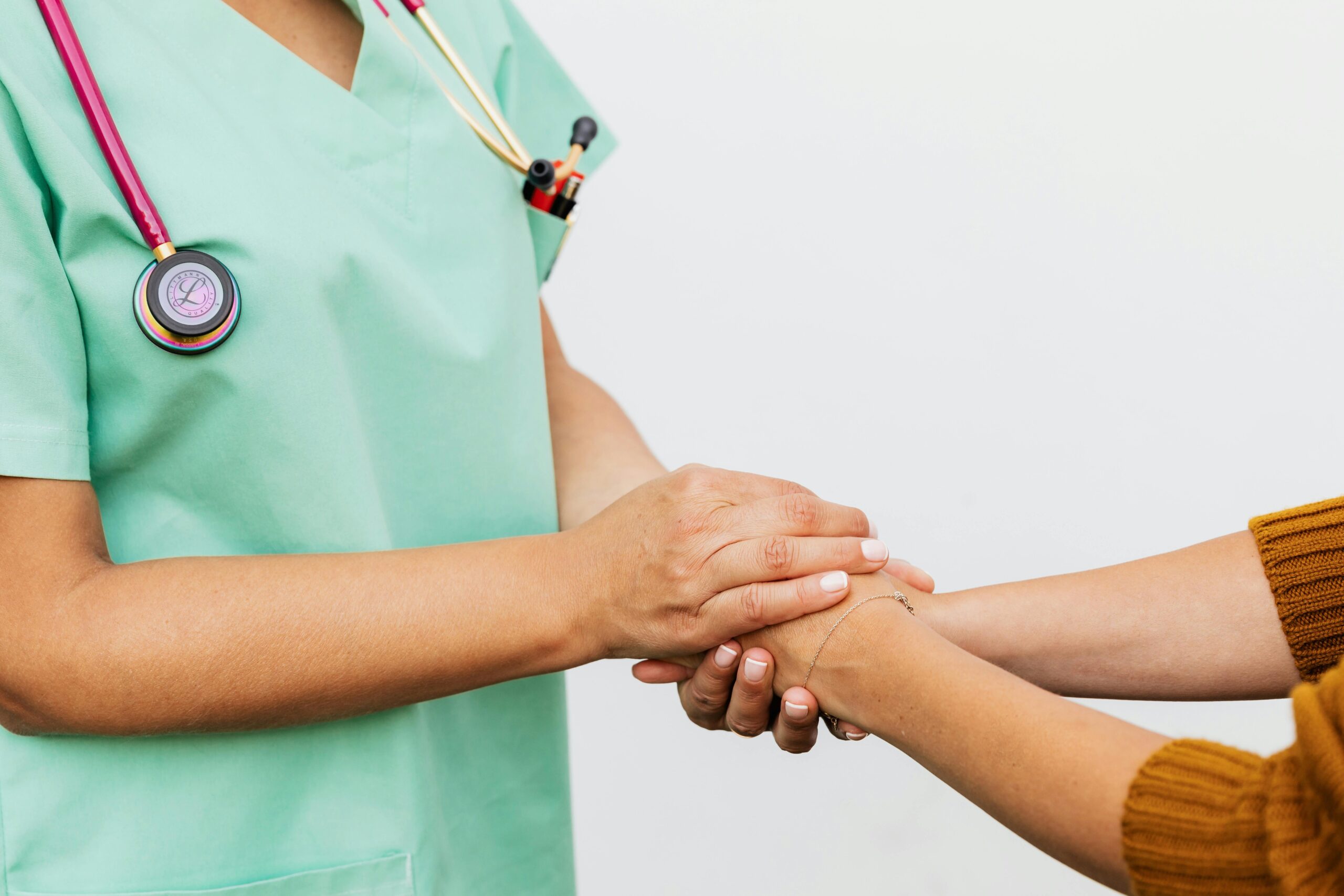 Close-up of a doctor holding a patient's hands, symbolizing trust and empathy in healthcare.