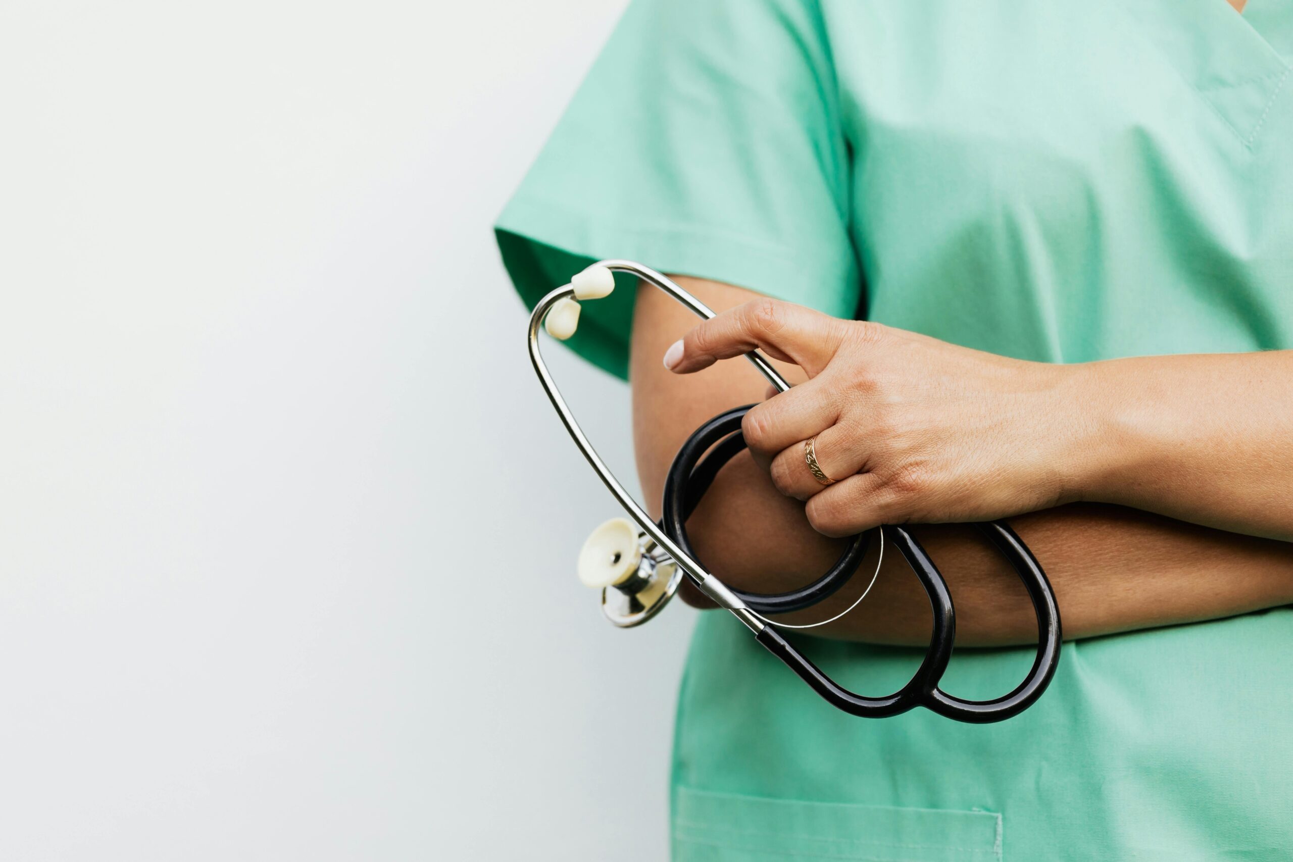 Close-up of a healthcare worker holding a stethoscope, showcasing medical professionalism.