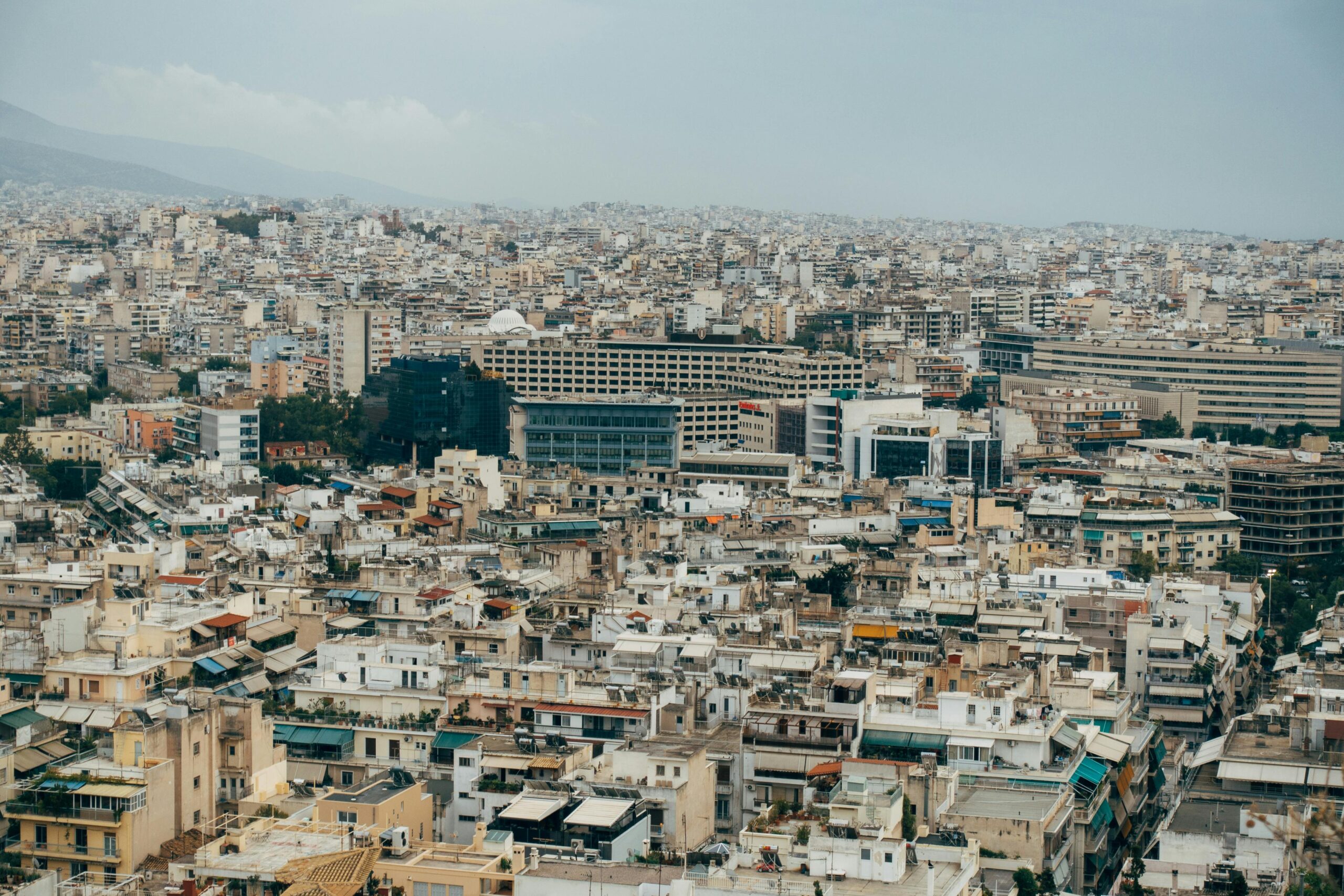 Expansive aerial view capturing the dense cityscape of Athens, Greece.