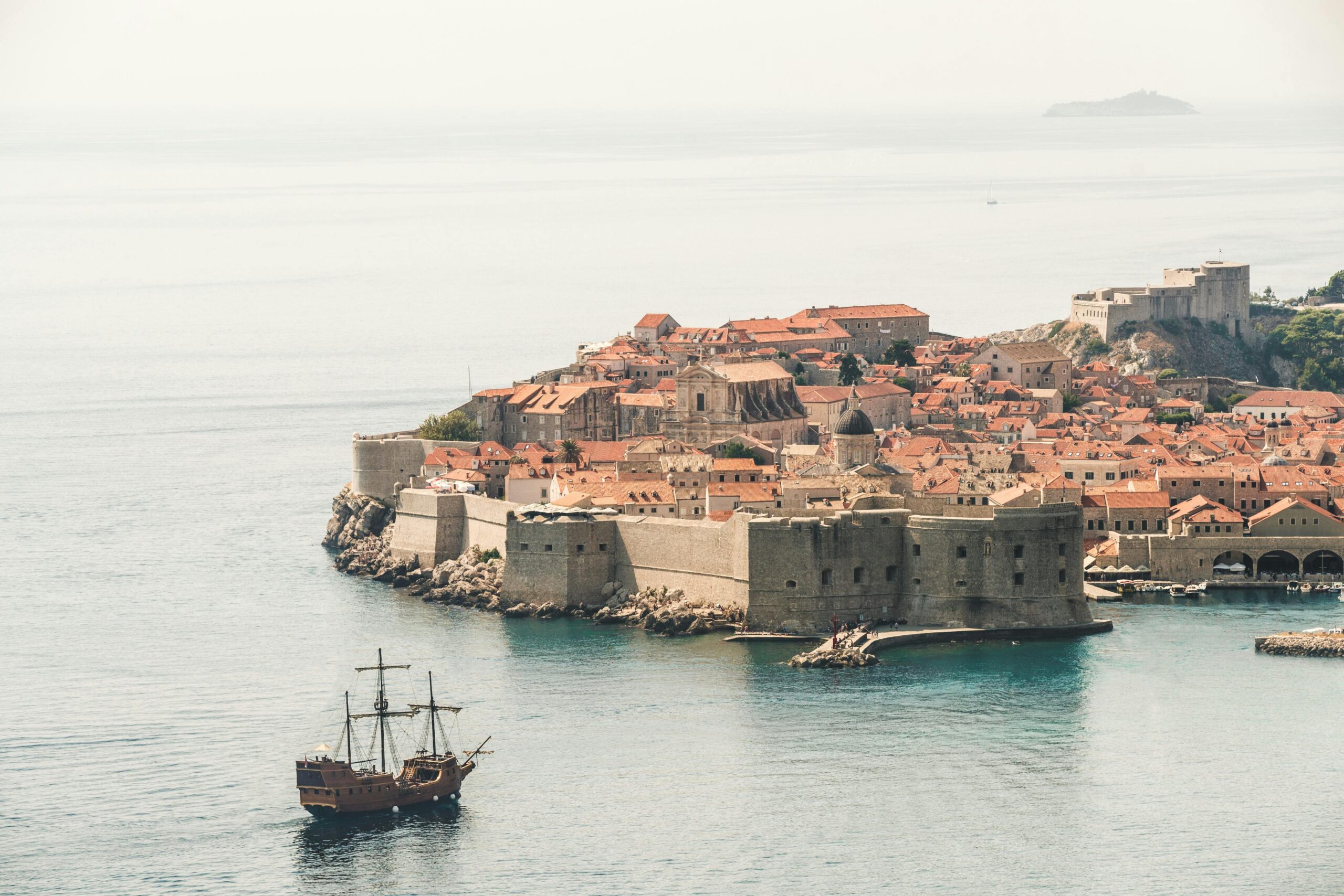 Stunning aerial photo of Dubrovnik's old town and city walls by the Adriatic Sea.
