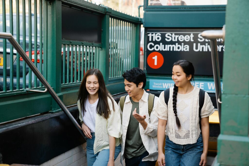Three young adults walking out of a subway station near Columbia University in New York City.