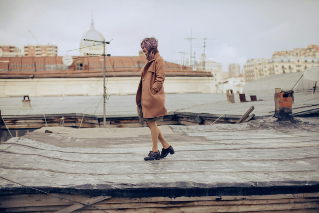 Woman in coat poses on rooftop in Agjabadi, Azerbaijan.