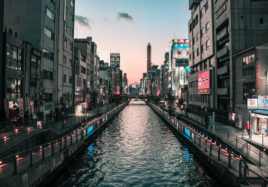 Stunning view of Dotonbori Canal in Osaka, Japan at twilight with vibrant city lights reflecting on the water.