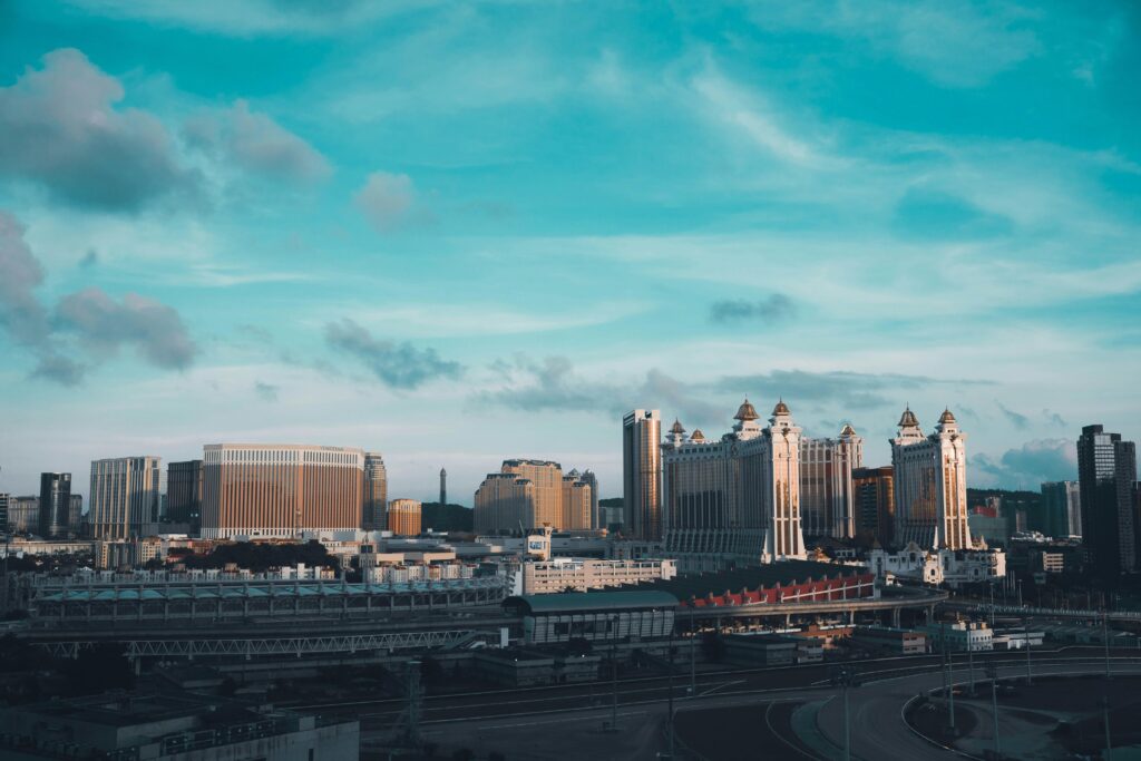 A stunning aerial view of Macau's skyline under a bright blue sky, featuring iconic casino architecture.
