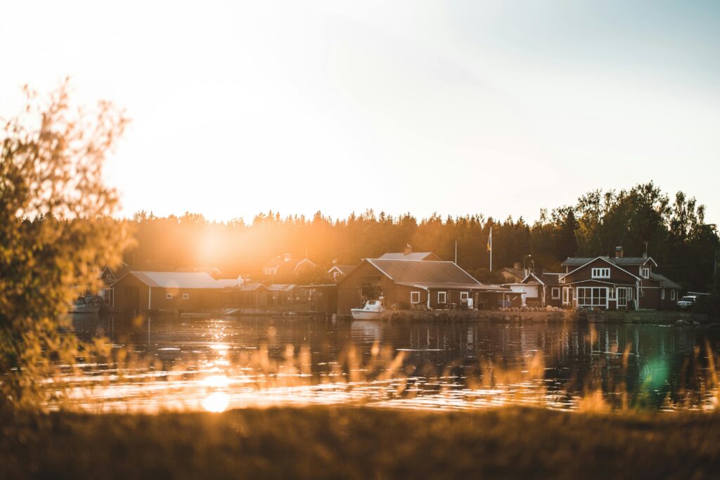 Peaceful lakeside cabins at sunset, capturing Scandinavian tranquility and nature's beauty.