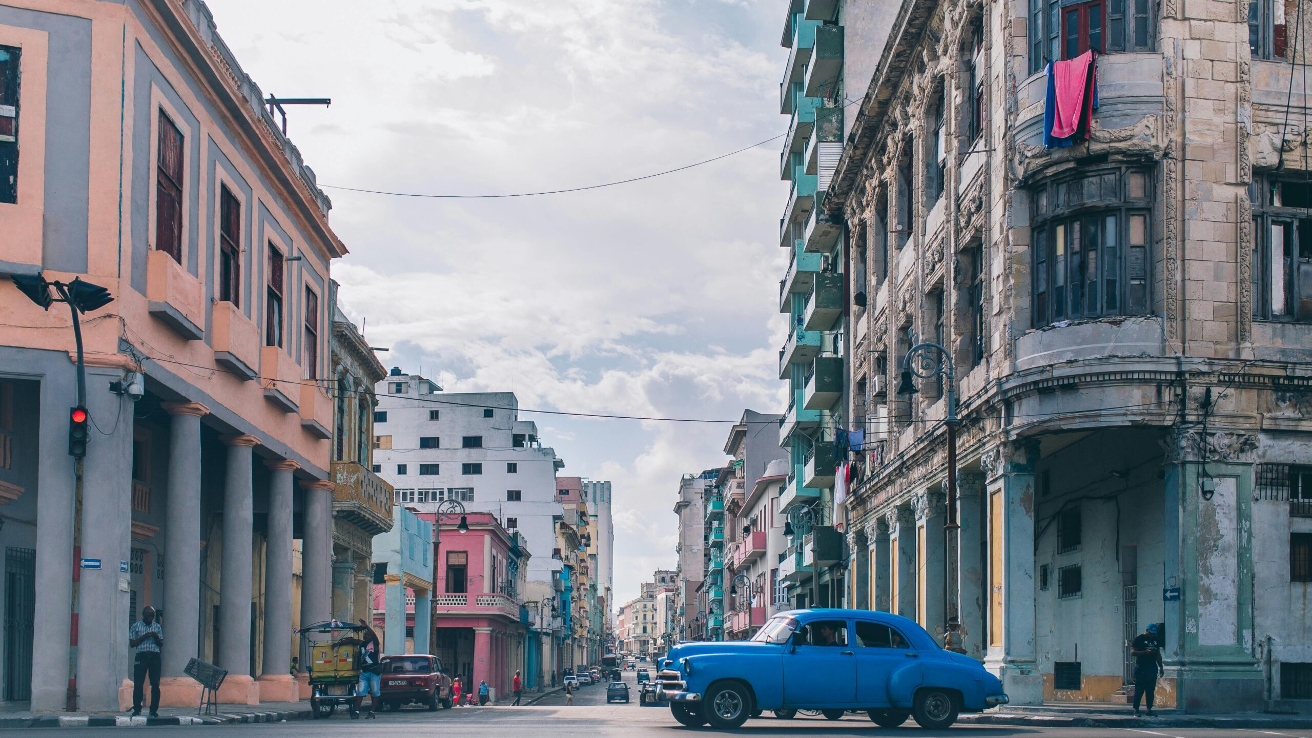Captivating urban scene in Havana with vintage architecture and classic blue car under a clear sky.