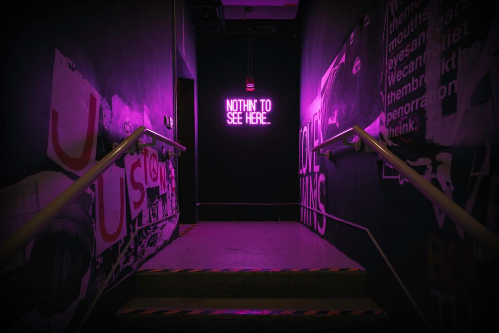 Dramatic neon-lit staircase with a unique illuminated sign creating an urban vibe.