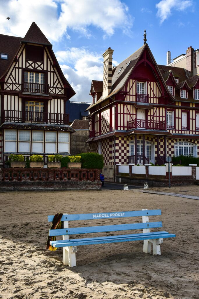Explore the picturesque beachfront architecture in Trouville, Normandy with the iconic Marcel Proust bench.