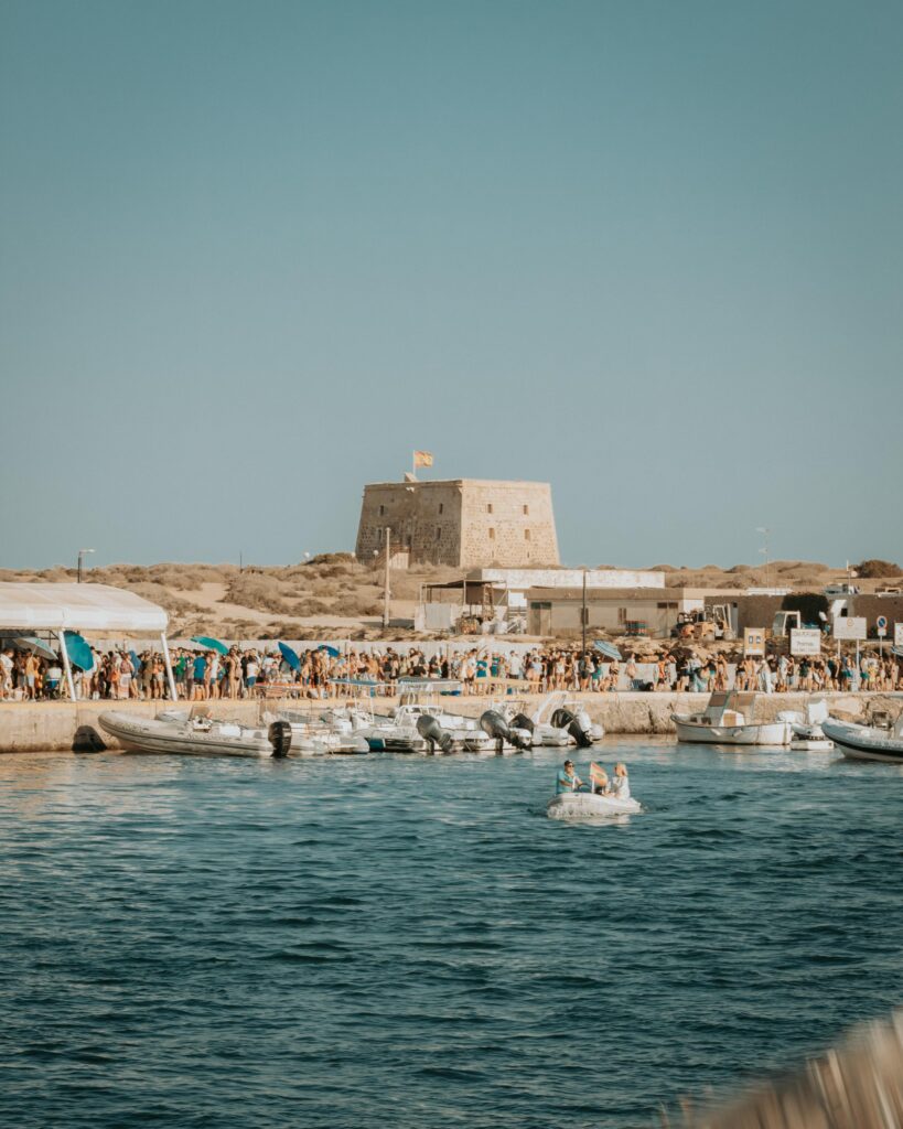 Explore the lively harbor of Tabarca Island, Spain, capturing its vibrant summer beauty.