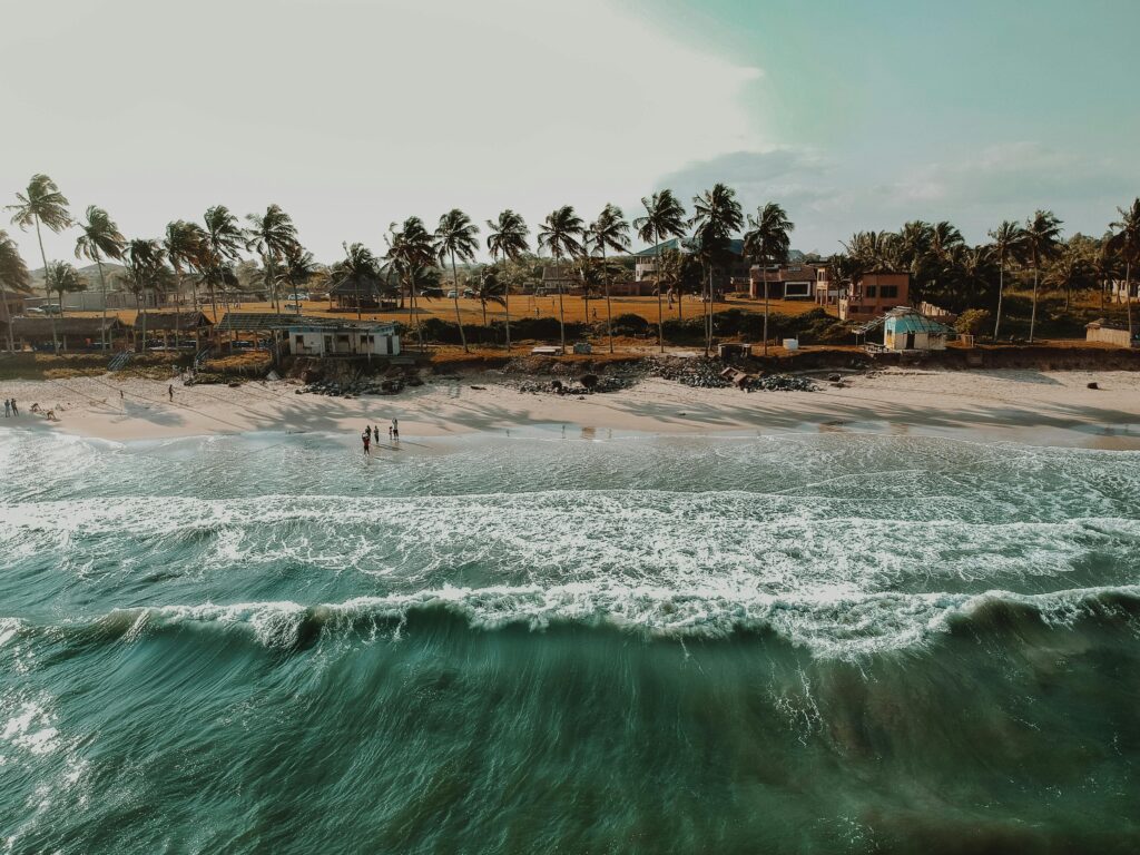 Stunning aerial view of a tropical beach with palm trees in Accra, Ghana, during sunset.